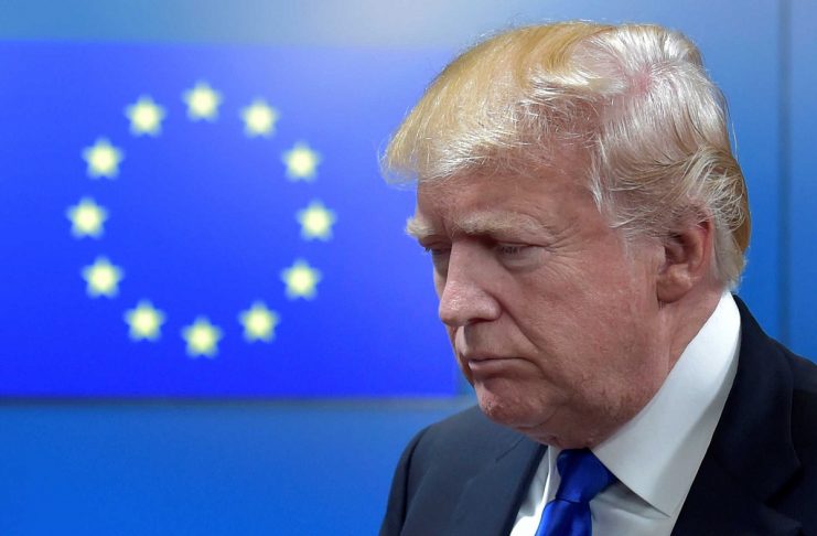 U.S. President Donald Trump reacts as walks with the President of the European Council Donald Tusk after a meeting in Brussels