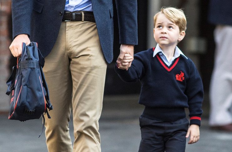 Prince George holds his father Britain’s Prince William’s hand as he arrives on his first day of school at Thomas’s school in Battersea, London