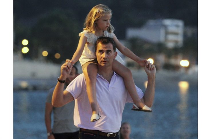 Spain’s Crown Prince Felipe carries his daughter Leonor while going for a walk in Port de Soller, on the Spanish Balearic island of Mallorca