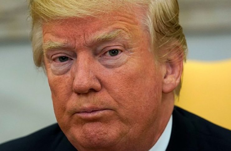 Trump looks up as reporters ask questions about Tillerson at the White House in Washington