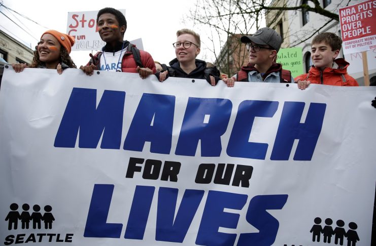 High school students carry a banner during a “March for Our Lives” demonstration demanding gun control in Seattle