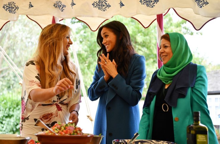 Meghan, Duchess of Sussex helps to prepare food at the launch of a cookbook with recipes from a group of women affected by the Grenfell Tower fire at Kensington Palace in London