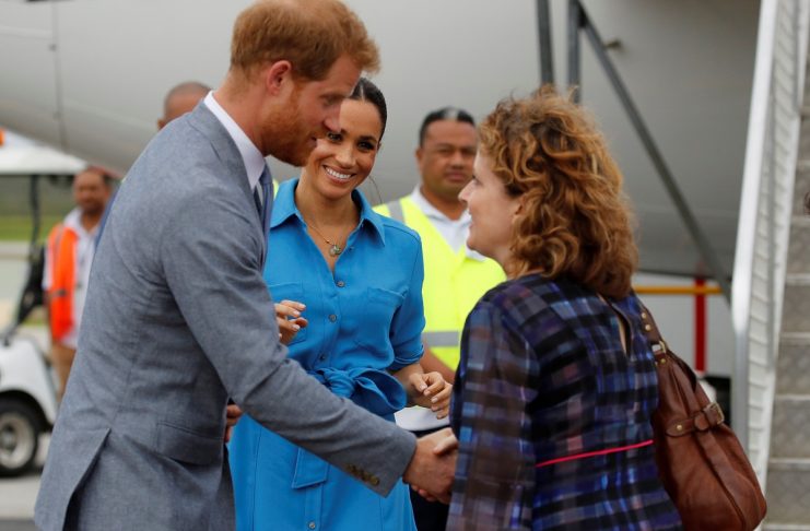 Britain’s Prince Harry and Meghan, Duchess of Sussex interact as they depart from Fua’amotu International Airport in Tonga