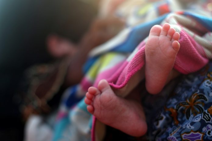 The feet of a newborn Rohingya refugee baby are seen at a port after crossing from Myanmar, in Teknaf